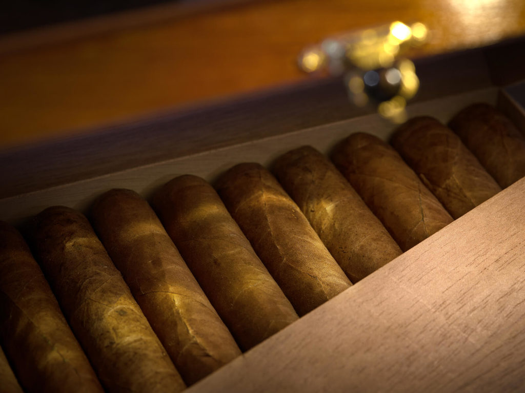 A humidor sits filled to the brim with high-quality cigars.