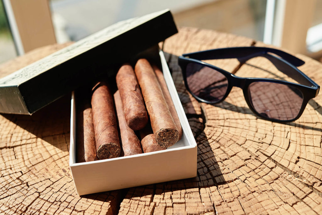 Cigars sat in the sun, stored in a cardboard box.