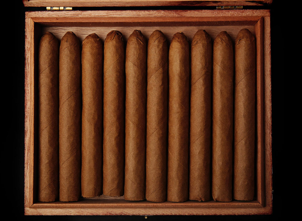 Cigars neatly lined within a humidor, ready for smoking.