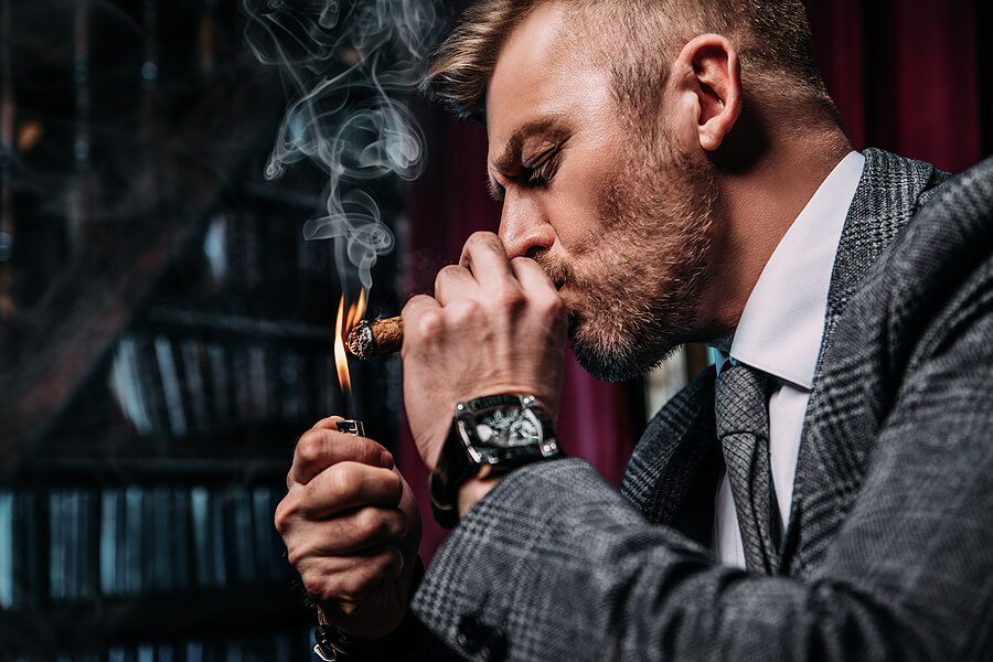 A Man enjoying a cigar in a lavish setting.