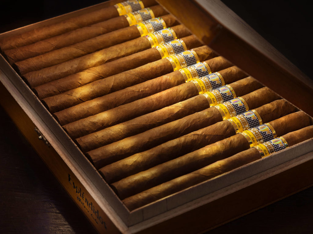 A row of cigars, neatly stored in a humidor.