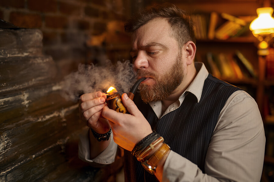 A smart gentleman lights his pipe.