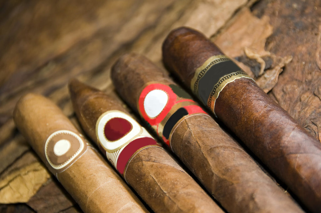 A variety of cigars laid out on a table.